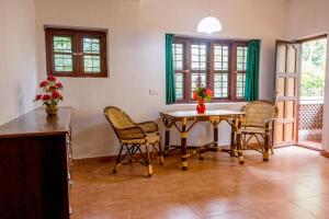 a dining room with a table and chairs at BASIS Mountain House in Thekkady