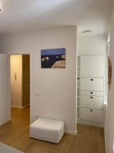 a white room with a white ottoman in a room at The Secret Lakeside in Gravedona