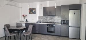 a kitchen with a table with chairs and a refrigerator at Villa Eliada in Tuzla