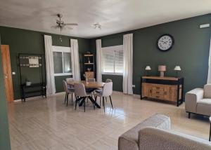 a living room with a table and chairs and a clock at Casa Castillo in Huércal-Overa