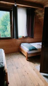 a bedroom with a bed and a window in a cabin at Nini Guesthouse Theth in Theth