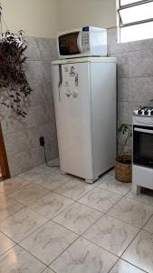 a microwave on top of a refrigerator in a kitchen at Mini Casa Tiradentes 2 in Tiradentes