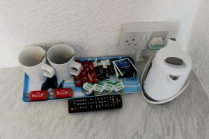 a table with two mugs and a remote control at Ride Side Delton Hotel in Blackpool