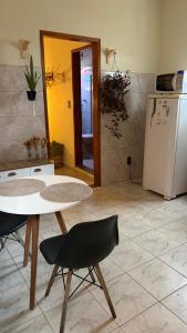 a kitchen with a table and a white refrigerator at Mini Casa Tiradentes 2 in Tiradentes