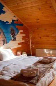 a bedroom with a bed with two towels on it at Skupis kokhebi in Mestia