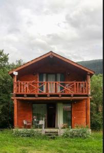 a wooden house with a balcony on top of it at Skupis kokhebi in Mestia