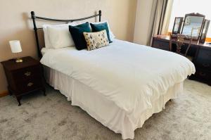 a bedroom with a large white bed with pillows at Tigh-na-lios, Inver in Inver