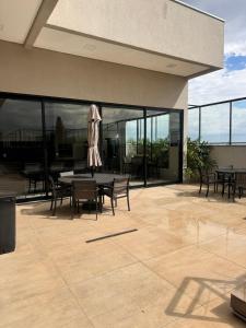 a patio with a table and chairs and windows at Studio próximo a UFU Sta Monica e Center shopping in Uberlândia