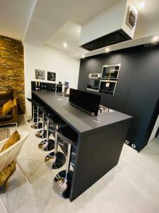 a kitchen with a long counter with stools in a room at jolie appartement in Seraing