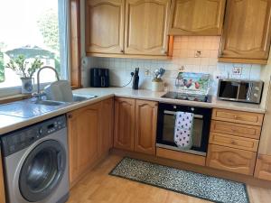 a kitchen with wooden cabinets and a dishwasher at Tigh-na-lios, Inver in Inver