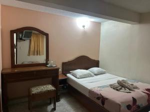 a bedroom with a bed and a vanity and a mirror at Cid Hotel Mérida in Mérida