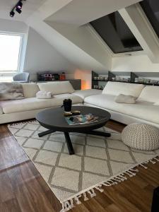 a living room with a couch and a coffee table at Modern Attic Loft in Weisenheim am Sand