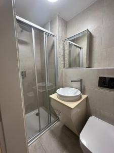 a bathroom with a shower and a toilet and a sink at Romarin in Marin