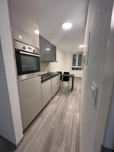 a kitchen with white appliances and a wooden floor at Romarin in Marin