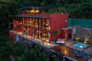 an aerial view of a red house with a pool at Villa Cavo - Beneath the Misty Peaks in Haputale