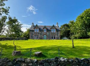 an old stone house on a grassy field at Lochinver Manse in Lochinver