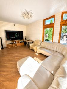 a living room with a couch and a tv at Flower 18 in Jūrmala +9 photos
