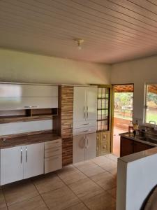 a large kitchen with white cabinets and a sink at KmX in Campo Grande