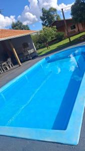 a blue swimming pool in front of a house at KmX in Campo Grande