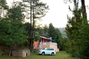 a car parked in front of a house at Canopy Court Farmhouse Murree in Bhurban