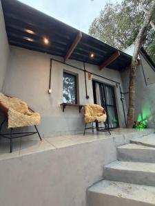 two chairs sitting on the porch of a house at Chalé Exclusive El Paso in Mairiporã