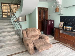 a living room with a chair and a staircase at Lara Homestay duplex 1bhk in Secunderabad