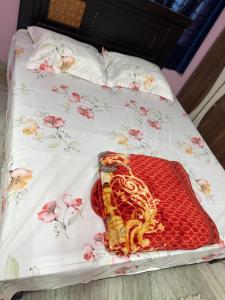 a bed with a flowered bedsheet with pink flowers on it at Lara Homestay duplex 1bhk in Secunderabad