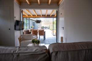 a living room with a couch and a dining room with a table at B&B by lin in Dodewaard