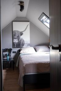 a bedroom with a bed and a painting on the wall at B&B by lin in Dodewaard