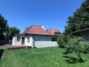a white house with a red roof in a yard at Tønder Byhus in Tønder