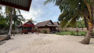 a resort with a building and a palm tree at Bintang Left Homestay Mentawai in Katiet