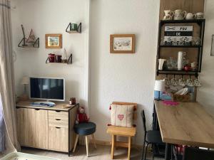a room with a desk with a television and a table at Orrianes 1650 in Les Orres