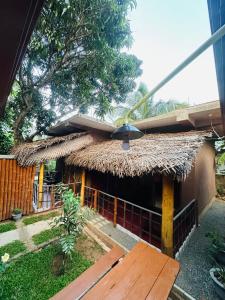 a house with a thatched roof and a wooden porch at Tuskers edge Retreat in Udawalawe