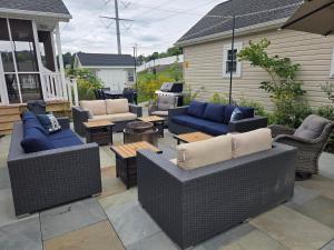 a patio with couches and tables on a house at Garden Guest Cottage in Harrisonburg