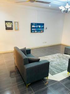 a living room with a couch in front of a wall at Joyet Guest House in Amasaman +11 photos