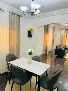 a white table with chairs and a vase of flowers on it at Joyet Guest House in Amasaman