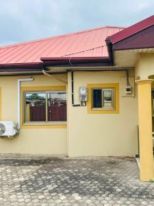 a house with a red roof and two windows at Joyet Guest House in Amasaman