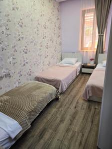 a bedroom with two beds and a wall with flowers at T'teni in Urtsʼadzor