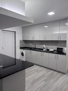 a kitchen with white cabinets and a black counter top at Casa Costa in Esmoriz