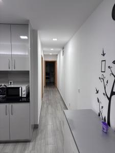 a kitchen with white cabinets and a hallway at Casa Costa in Esmoriz