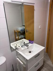 a bathroom with a white sink and a mirror at Casa Costa in Esmoriz