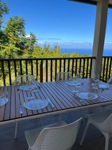 a wooden table with chairs and wine glasses on a balcony at Villa Inelda in Saint-Paul