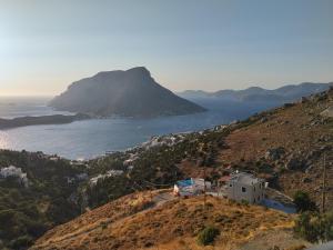 a van parked on a hill next to the ocean at Symbligates rocks in Kalymnos