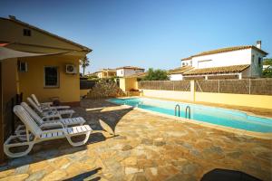 a pair of lounge chairs next to a swimming pool at Casa Tati Strand in Sant Pere Pescador