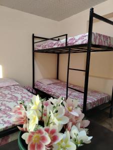 a room with two bunk beds with flowers on a table at Tamari in Ureki