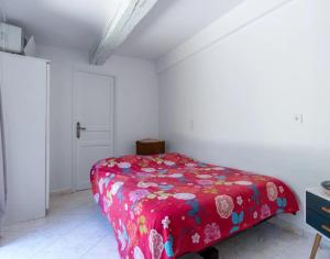 a bedroom with a red bed in a white room at Chambre dans charmant Cottage dans résidence agréable in Grasse