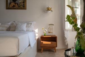 a bedroom with a bed and a table with a night stand at Allium Art House Symi in Symi