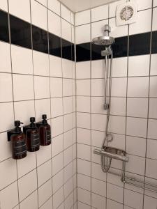 a shower with three bottles on a tiled wall at Tiny house at Enhrna in Enhörna