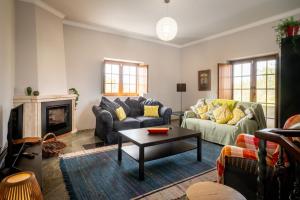 a living room with two couches and a coffee table at Quinta da Palhota in Vila de Rei
