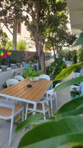 a wooden table and chairs in a garden with plants at OASIS Central 007 in Rhodes Town